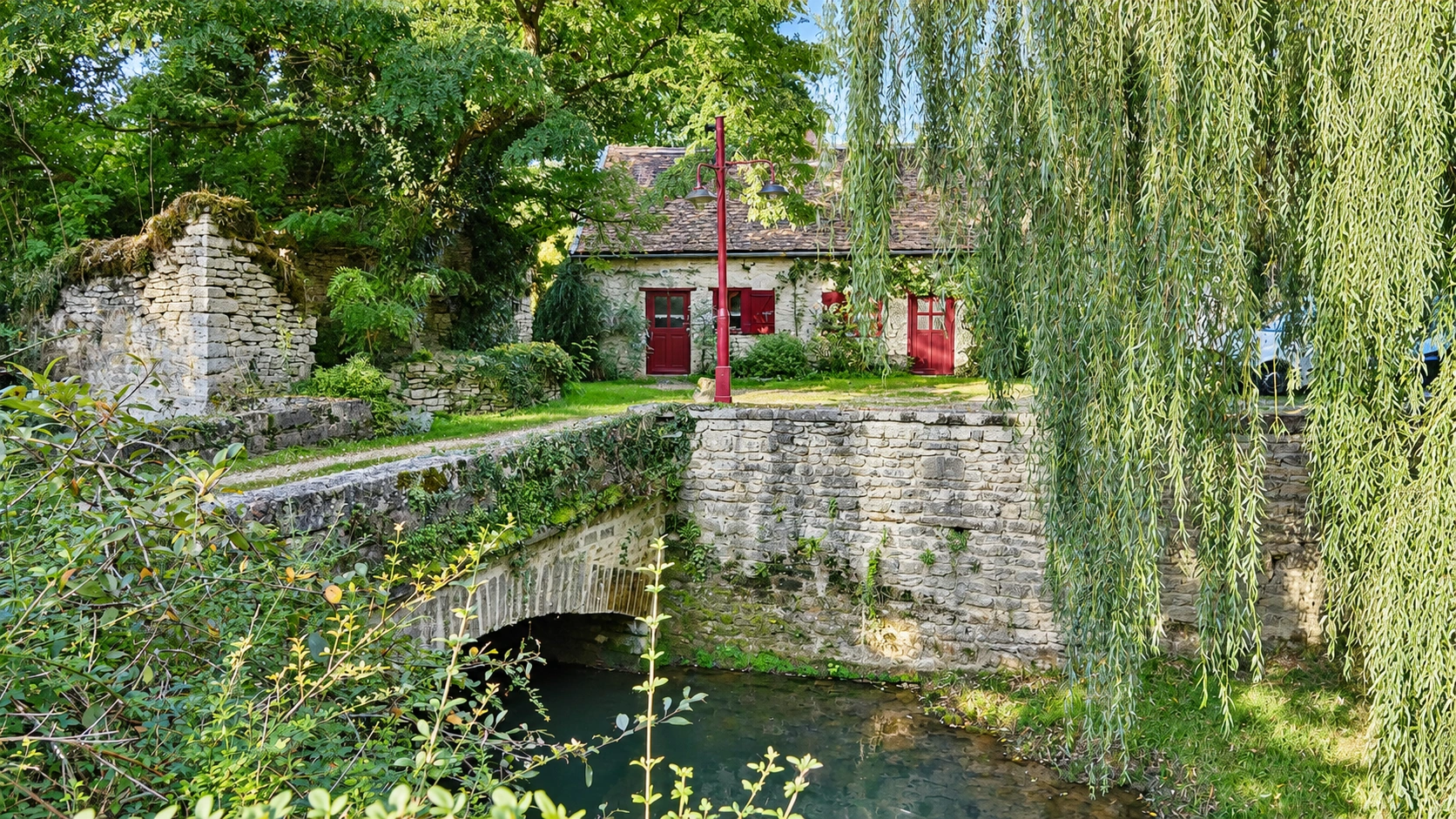 El puente de piedra y las casas rurales rodeadas de vegetación